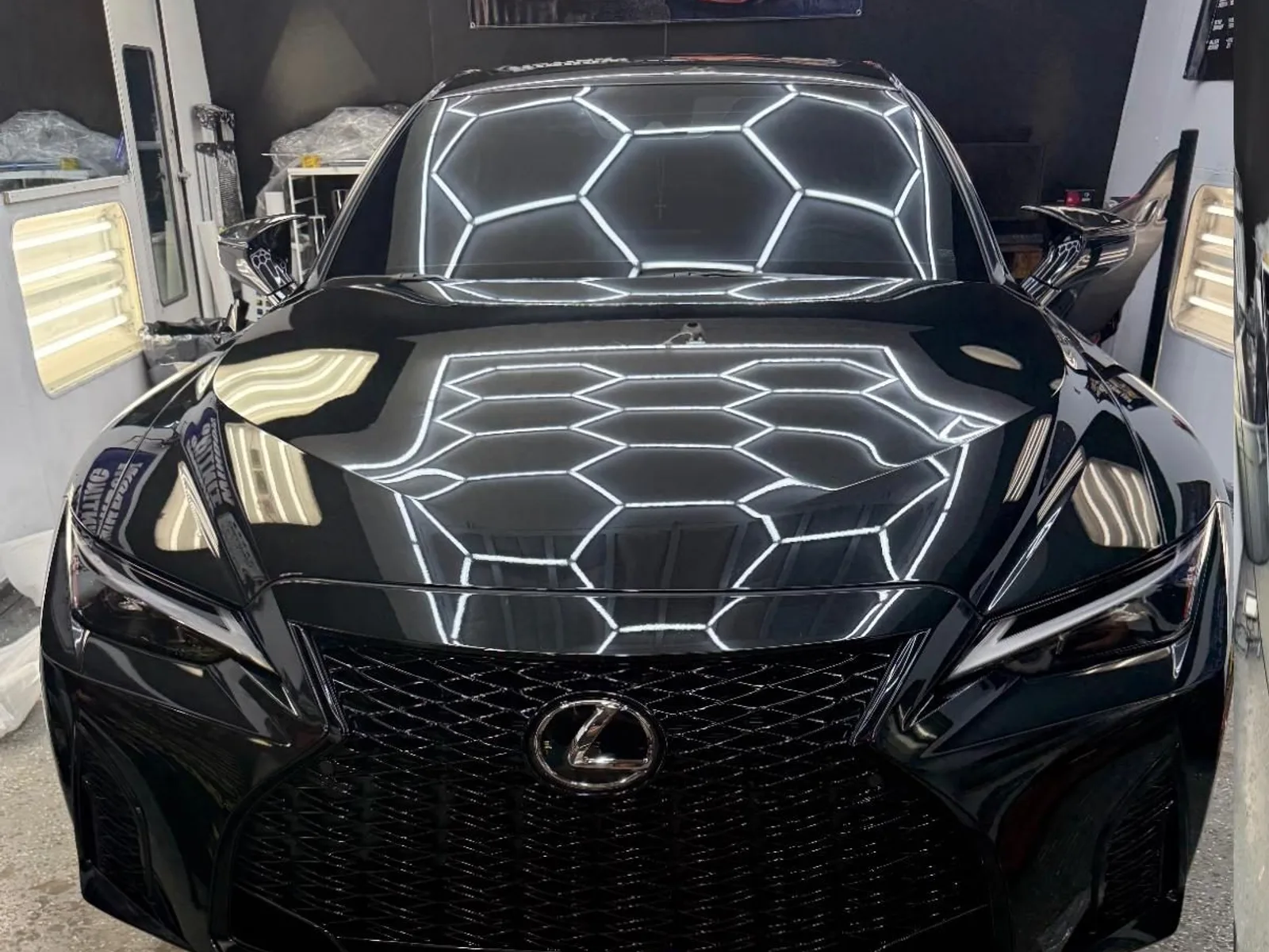 Black Lexus under the shop's hexagon lights